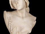 marble bust of a woman with a flowered dress on a black background