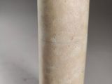 beige vase with a brown lid sitting on a white surface