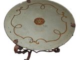 a plate on a stand with a design on it