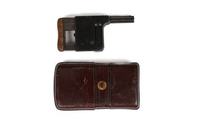 un pistolet et un portefeuille posés sur une surface blanche