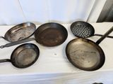 a lot of frying pans on a table