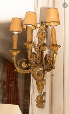 un lustre en or suspendu à un miroir dans une pièce