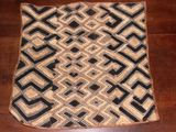 une photo d'un tapis noir et blanc posé sur un parquet
