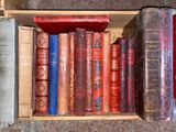 many old books in a wooden box on the floor