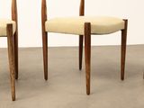 three wooden chairs with beige upholstered seats in a room