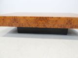 a wooden coffee table with a black base and a wooden top