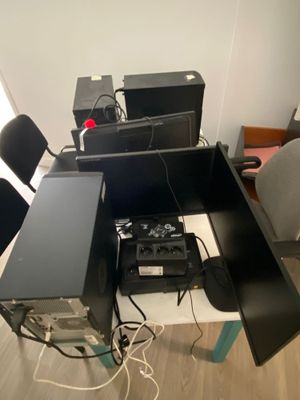 a lot of computers and speakers on the desk