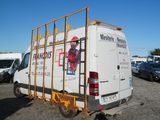 a van that is parked in a lot with other vehicles