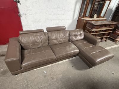 un canapé et un pouf en cuir marron dans une pièce