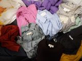 une pile de vêtements posée sur un lit