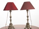 pair of red lamps sitting on top of a wooden table next to each other