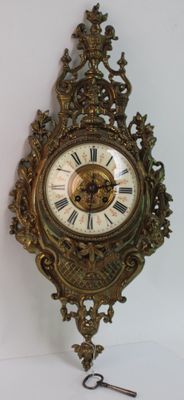 une horloge accrochée au mur, avec une clé