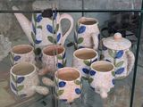 a glass display case with a variety of pottery items