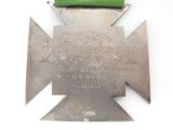 a silver medal with a green ribbon on a white background