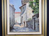 an oil painting of a street scene in a frame on a easel