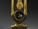 a clock that is sitting on a stand with a clock on it