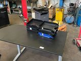 a black table with a laptop on it in a garage