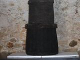 une pile de casseroles noires posée sur une table devant un mur de briques