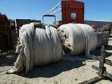 un gros rouleau de corde posé par terre près d'une clôture