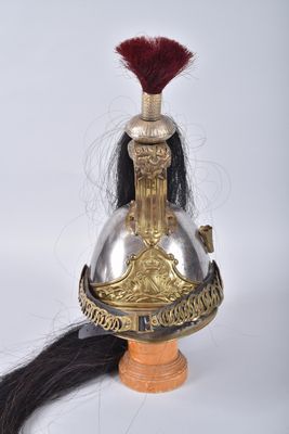 a gold helmet with a red feather on top of it