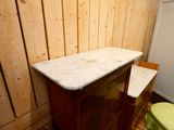 a wooden cabinet with a marble top in a bathroom