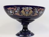 a blue bowl sitting on top of a black pedestal