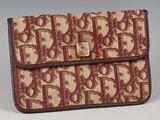 brown and tan purse with monogramming on it on a gray surface