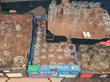 many empty glasses on a table with boxes of empty glasses