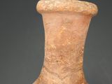 someone is holding a small vase in their hand against a black background