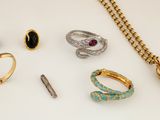 several rings, bracelets, and other jewelry on a white surface