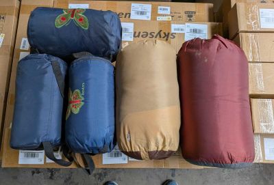 several bags of luggage are stacked on top of boxes in a warehouse
