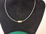 necklace on a black mannequin with a green box on a white background