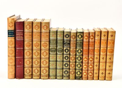 several old books are lined up in a row on a white surface