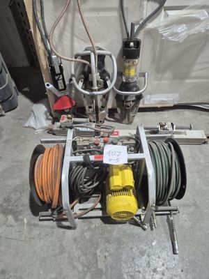 une machine posée par terre à côté d'un tuyau d'arrosage