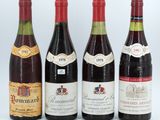 four bottles of wine are lined up on a white surface