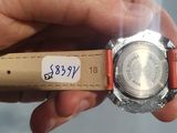 a person holding a watch in their hand with a sticker on it