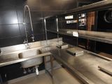 une cuisine avec des plans de travail en inox et un évier