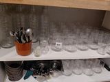 many glasses and spoons on a shelf in the kitchen