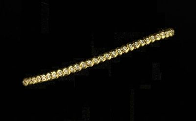 yellow gold tennis bracelet with diamonds on a black background