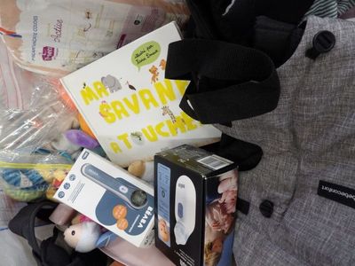 a bag full of baby items on a bed