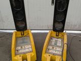 two yellow traffic lights sitting next to each other in front of a building