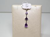 une image représentant une paire de boucles d'oreilles ornées de cristaux violets