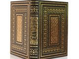 un livre noir et doré posé sur une surface blanche