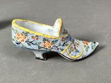 pair of blue and yellow shoes with flowers on them sitting on a table