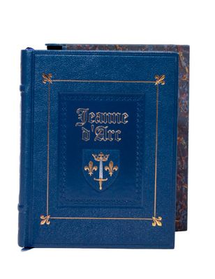 un vieux livre bleu aux bords dorés, avec une croix sur la couverture