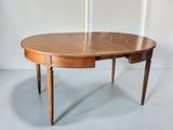 an oval dining table with two leaves on the top of it