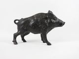 une petite figurine de cochon noir sur fond blanc
