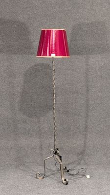 lampe sur pied avec un abat-jour rouge, montée sur un trépied métallique