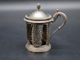 an antique silver teapot with a lid on a table