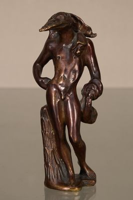 bronze statue of a man holding a bird on a tree stump